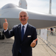 Turkish Aerospace CEO Temel Kotil makes the thumbs up sign as he poses next to a mock-up of a TF-X fighter jet displayed at Paris Air Show, in Le Bourget, east of Paris, France, Tuesday, June 18, 2019.